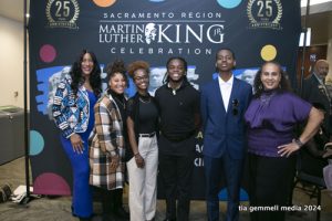 Attendees at MLK Celebration Sacramento event posing in front of official event banner